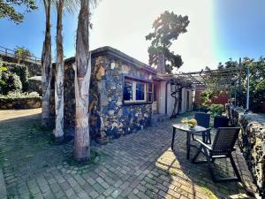una casa con mesa, sillas y árboles en Finca Oscar Burchard en La Orotava