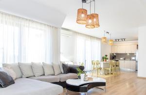 a living room with a white couch and a table at Vitosha Downtown Apartments in Sofia