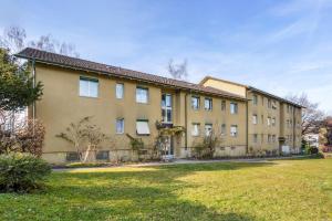 a large building with a yard in front of it at Charming Apartments, Just 27 Minutes to Zurich Center in Zurich
