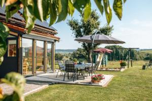 un patio con mesa, sillas y sombrilla en Ferienholzhaus Füßmann, en Ahortal