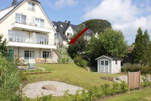 a large white house with a red arrow in a yard at Residenz am Hafen Boddensuite in Ahrenshoop