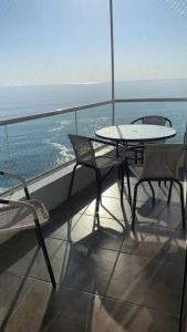 a table and chairs on a balcony with the ocean at Apartamento en Iquique. in Iquique +7 photos