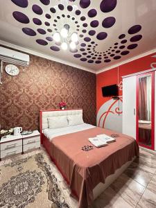 a bedroom with a bed with a red wall at Lux in Türkistan
