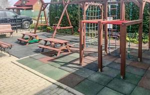 a playground with two benches and a swing set at Cozy Home In Rewal With Wi-fi in Rewal