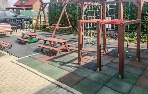 a playground with two benches and a swing set at Cozy Home In Rewal With Wi-Fi in Rewal