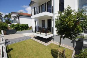 a large white house with a yard in front of it at Aquamarin Ostseetraumsuite 01 in Neuhaus