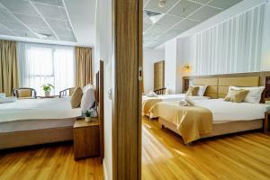 um quarto de hotel com duas camas e uma janela em SIR FUNDENI HOTEL em Bucareste