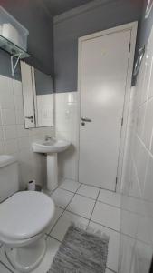 uma casa de banho com um WC branco e um lavatório. em Apartamento inteiro com garagem coberta em União da Vitória