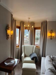 a living room with a couch and a chair and a table at Ferienapartment Residenz "Weisses Rössl am See" in Thiersee