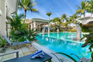 a pool at a resort with palm trees at Poolside Bliss: A Modern Resort Sanctuary in Port Douglas