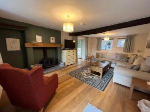 a living room with a couch and a fireplace at Beech Cottage - Skelwith Bridge in Elterwater