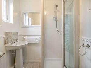 a white bathroom with a sink and a shower at 2 Bed in Wasdale SZ436 in Santon Bridge +11 photos