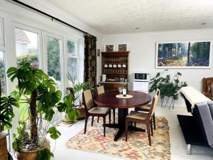 a dining room with a table and some plants at Karinya suite in Llanvaches