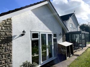 a white house with a large sliding glass door at Karinya suite in Llanvaches