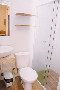 a bathroom with a toilet and a glass shower at Pousada do gaúcho in Barreirinhas
