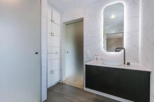 een badkamer met een wastafel en een spiegel bij Astoria House in Gistel