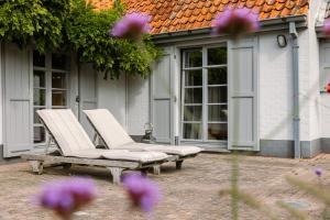 twee stoelen en een bank voor een huis bij Astoria House in Gistel