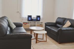 a living room with two leather couches and a table at Paganamaa puhkemaja ja peosaal in Liguri