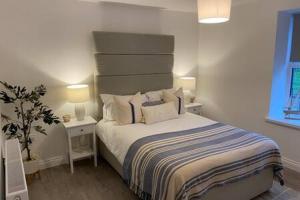 a bedroom with a bed and two tables and two lamps at Forest Cwtch by Afan Valley Escapes in Port Talbot