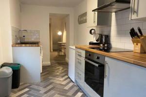 a kitchen with a sink and a stove top oven at Forest Cwtch by Afan Valley Escapes in Port Talbot