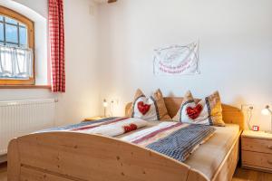 a bedroom with a wooden bed with pillows on it at Thomasegg Hof Linde in Sarntal