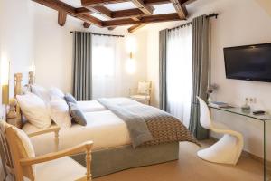 a bedroom with a bed and a desk and a television at Relais et Chateaux La Bonne Étape in Château-Arnoux-Saint-Auban