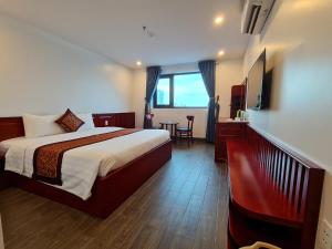 Cette chambre comprend un grand lit et une table. dans l'établissement glory 3 hotel 北宁格洛瑞3好酒店, à Bồ Sơn