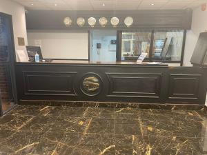 a lobby with a cash counter with clocks on the wall at Hylands Hotel in Coventry