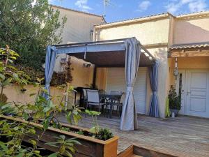 eine Terrasse mit blauem Baldachin auf einer Terrasse in der Unterkunft Maison confort et charme in Saint-Jean-de-Védas