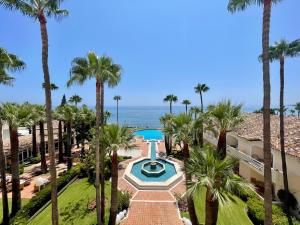 an aerial view of a resort with a swimming pool and palm trees at Las Dunas Grand Luxury in Estepona