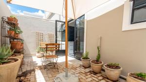 un patio con macetas y sombrilla en Franschhoek Colours en Franschhoek
