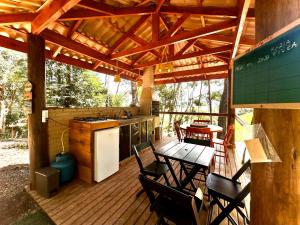 une terrasse en bois avec une cuisine, une table et des chaises dans l'établissement Carroça Colorado, Vila Mágica, à Bueno Brandão