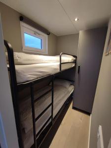 a bunk bed in a small room with a window at Atlanta. Een buitengewone ervaring. Dicht bij AMS. in Vinkeveen
