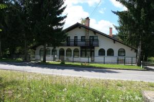 ein weißes Haus am Straßenrand in der Unterkunft Apartment Licka Vodenica in Josipdol