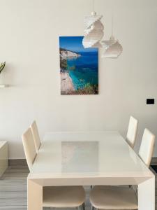 ポルトフェッラーイオにあるSuite del Portoの白いダイニングルーム(テーブル、椅子付)