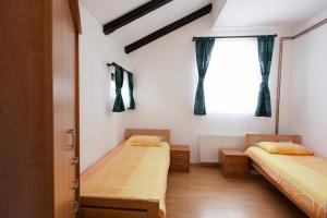 zwei Betten in einem Zimmer mit Fenster in der Unterkunft Apartment Licka Vodenica in Josipdol