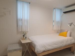a small bedroom with a bed with a yellow pillow at Coco Stay in Seoul