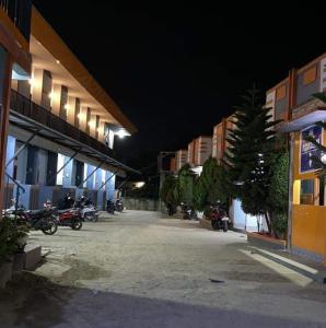 un groupe de motocycles garés de nuit à côté des bâtiments dans l'établissement PENGINAPAN 77, à Pulupanda