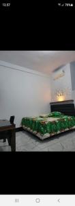 - une chambre avec un lit et une couette verte dans l'établissement PENGINAPAN 77, à Pulupanda