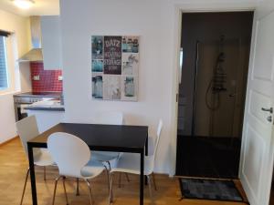 een eetkamer met een zwarte tafel en witte stoelen bij Feelhome Borgtun One bedroom cozy apartment in Tromsø