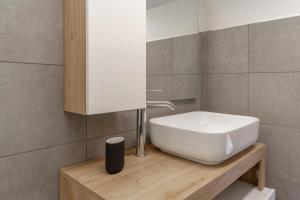a bathroom with a white sink on a wooden counter at Matteotti Gallery Venice Apt in Mestre +28 photos