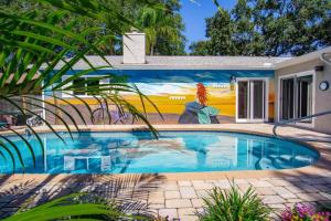 een zwembad met een schilderij aan de zijkant van een huis bij The Cycling Mermaid Palm Harbor, Florida - Bonus Travel Itinerary! in Palm Harbor