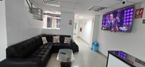 a waiting room with a couch and a tv at HOTEL TICLIO in Cajamarca