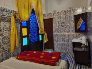 1 dormitorio con 1 cama con manta roja en Dar Lalla Kenza en Fez