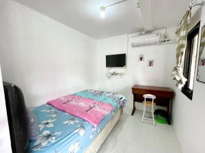 a small bedroom with a bed and a desk at Dehome near Pakuwon Mall in Surabaya