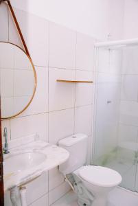 a white bathroom with a toilet and a sink at Pousada do gaúcho in Barreirinhas