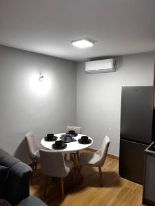 uma cozinha com uma mesa com cadeiras e um frigorífico em Apartman Jovana em Herceg Novi