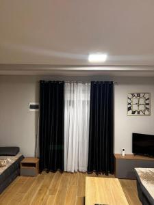 uma sala de estar com um sofá e uma grande janela em Apartman Jovana em Herceg Novi