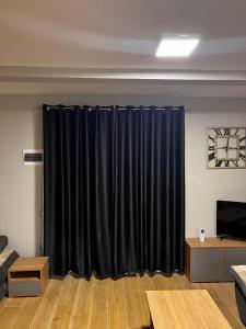 uma sala de estar com cortinas pretas num quarto em Apartman Jovana em Herceg Novi
