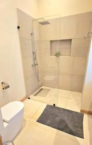 a bathroom with a shower and a toilet at Golf View Villa in Roches Noires
